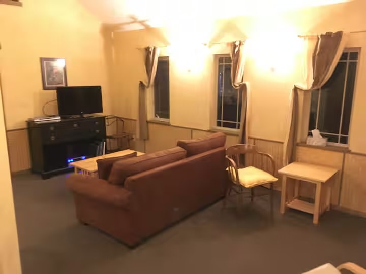 Spacious living room with sofa, coffee table and wood stove